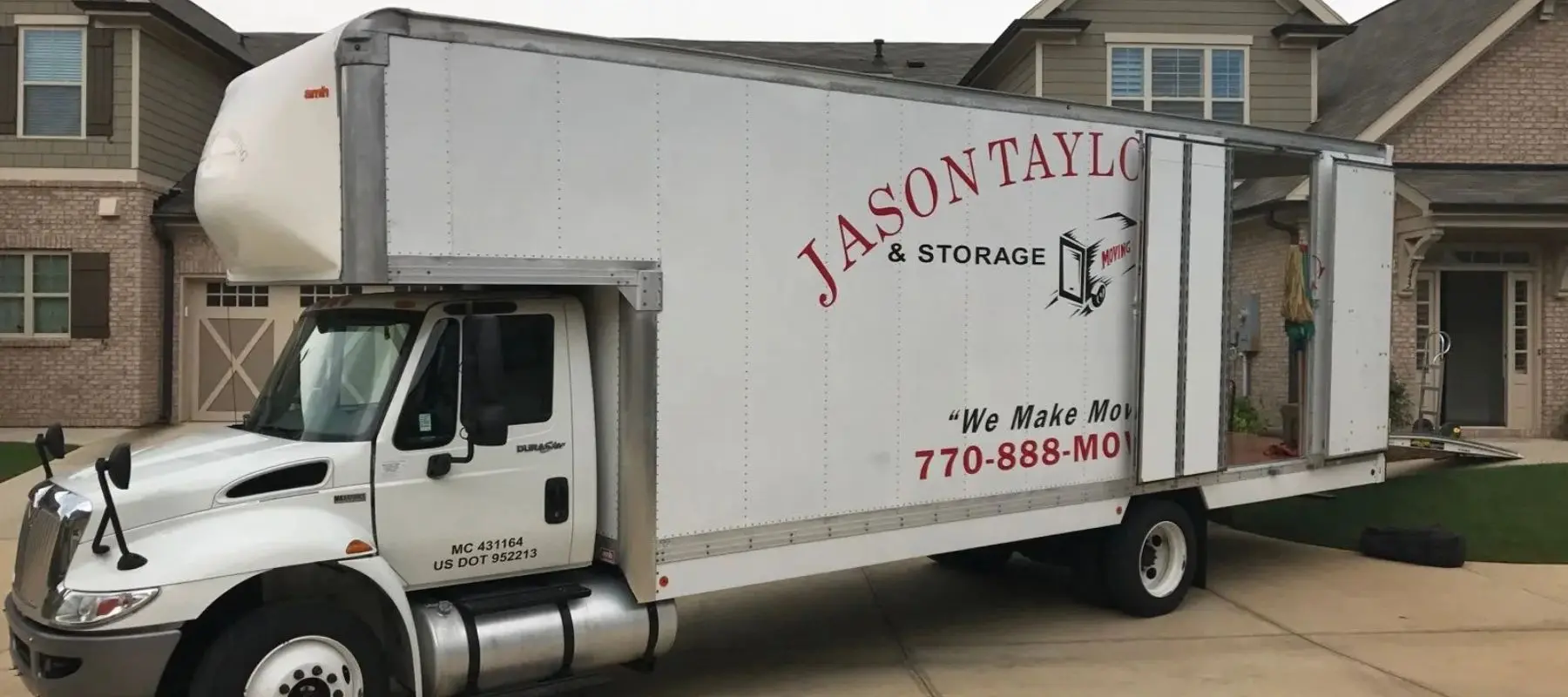White Jason Taylor & Storage box truck parked in a suburban driveway.